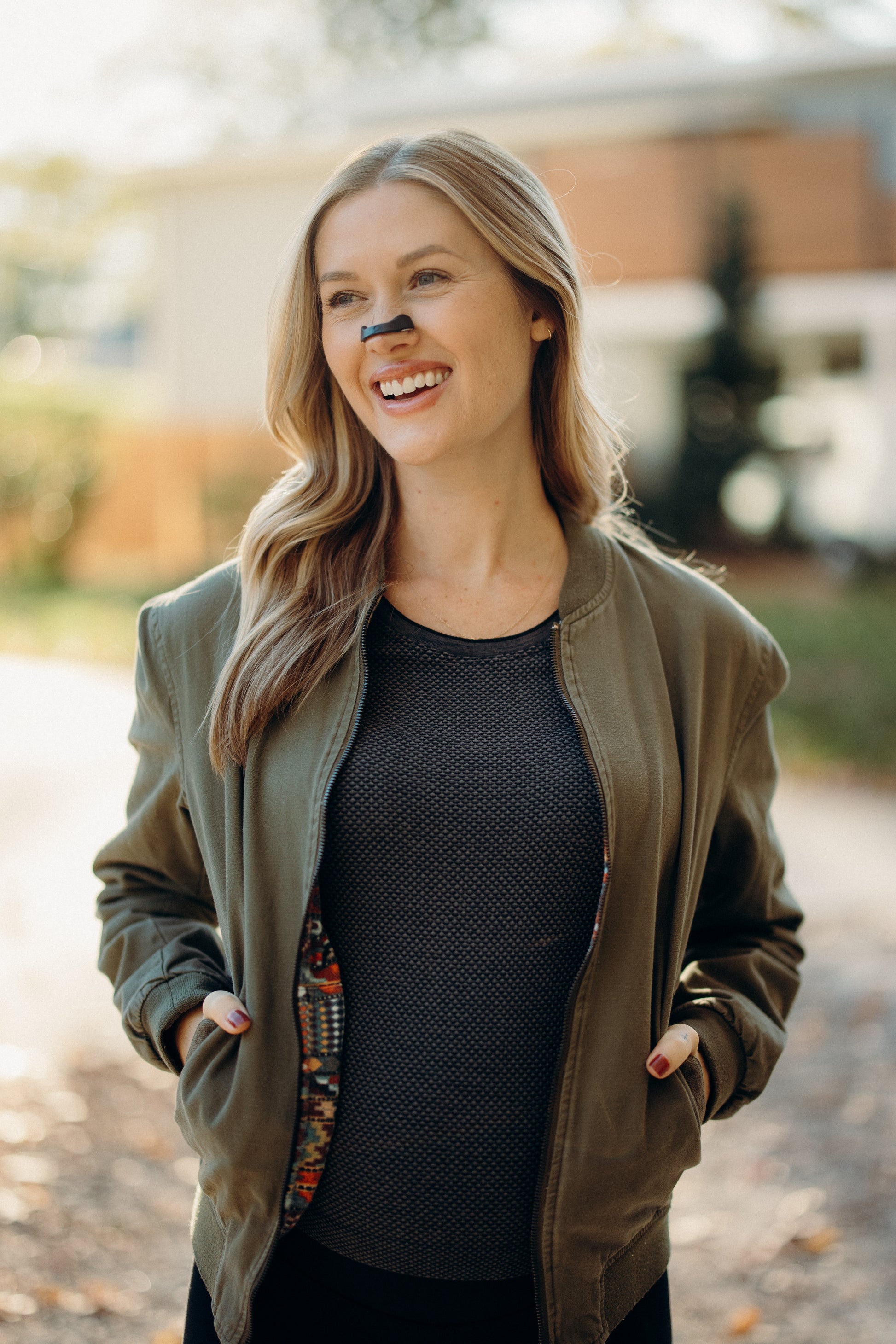 Woman wearing a green coat and black shirt outdoors